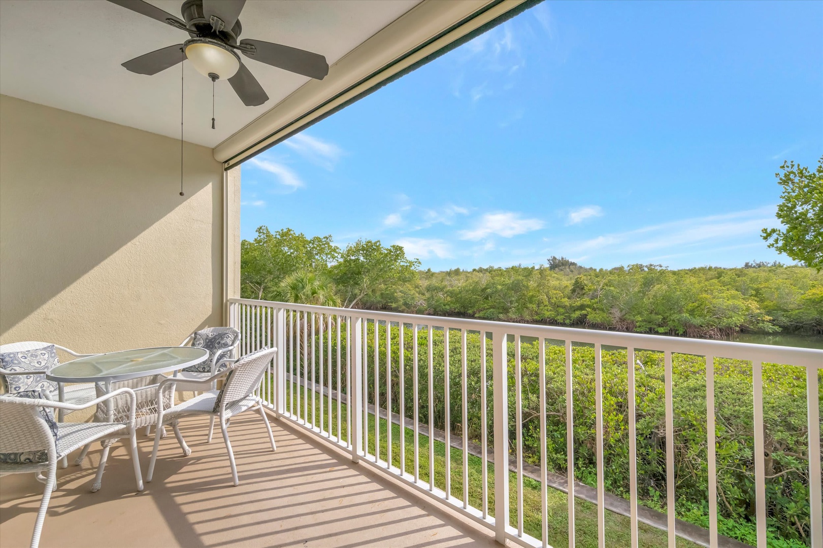 Sip your morning coffee on your private balcony while soaking in peaceful views of lush mangroves and open sky. The ceiling fan keeps you cool as you unwind in this serene outdoor retreat.
