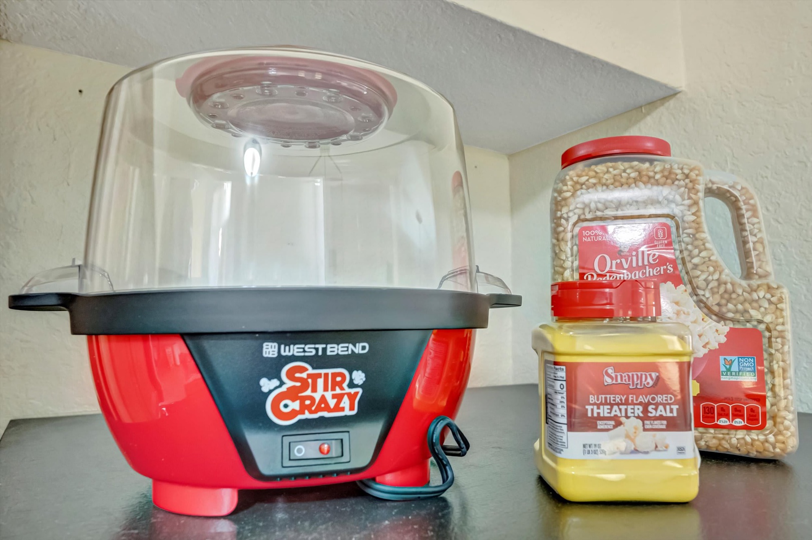A fun popcorn maker stands ready for your movie nights, complete with fresh kernels and theater-style butter salt to make every evening feel like a special occasion.