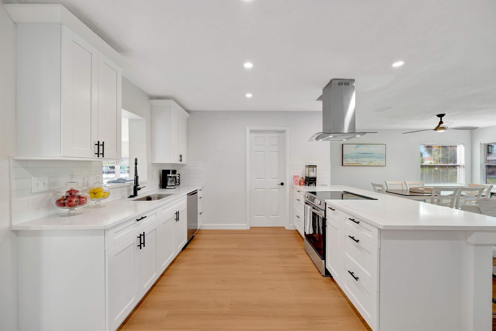 Step into your bright, modern kitchen where crisp white cabinetry and gleaming quartz counters invite you to whip up coastal-inspired meals, while warm wood floors add a welcoming touch.
