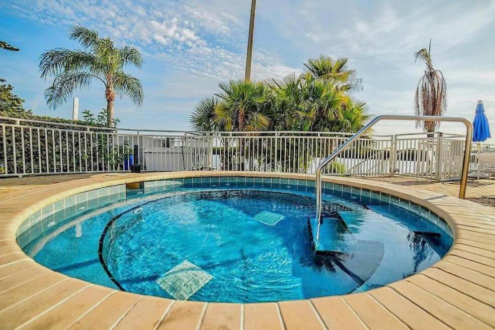 Soak in the sunshine at this inviting circular pool, surrounded by swaying palms and a peaceful waterfront backdrop—your perfect tropical escape awaits.