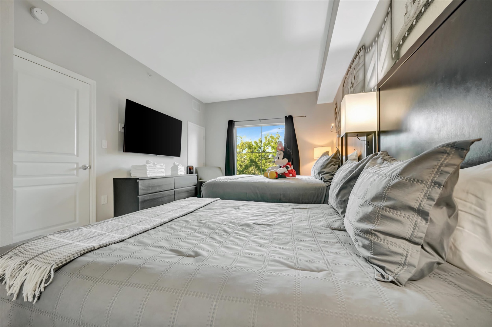 Sink into plush bedding and unwind in your serene retreat, where soft gray tones and modern comfort invite restful nights after days of adventure.