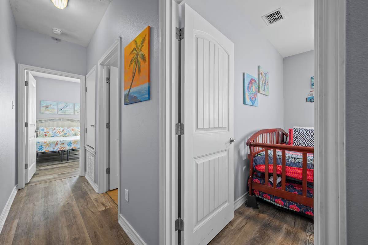 A welcoming hallway connects your private spaces, decorated with cheerful coastal artwork and a cozy reading nook ready for quiet moments.