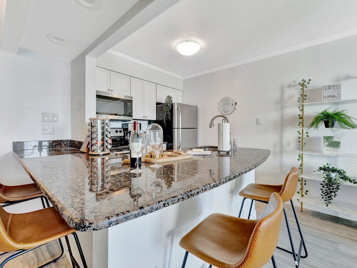 Your modern kitchen features gleaming granite countertops, full-size stainless appliances, and a breakfast bar with leather seating—perfect for cooking and sharing meals together.