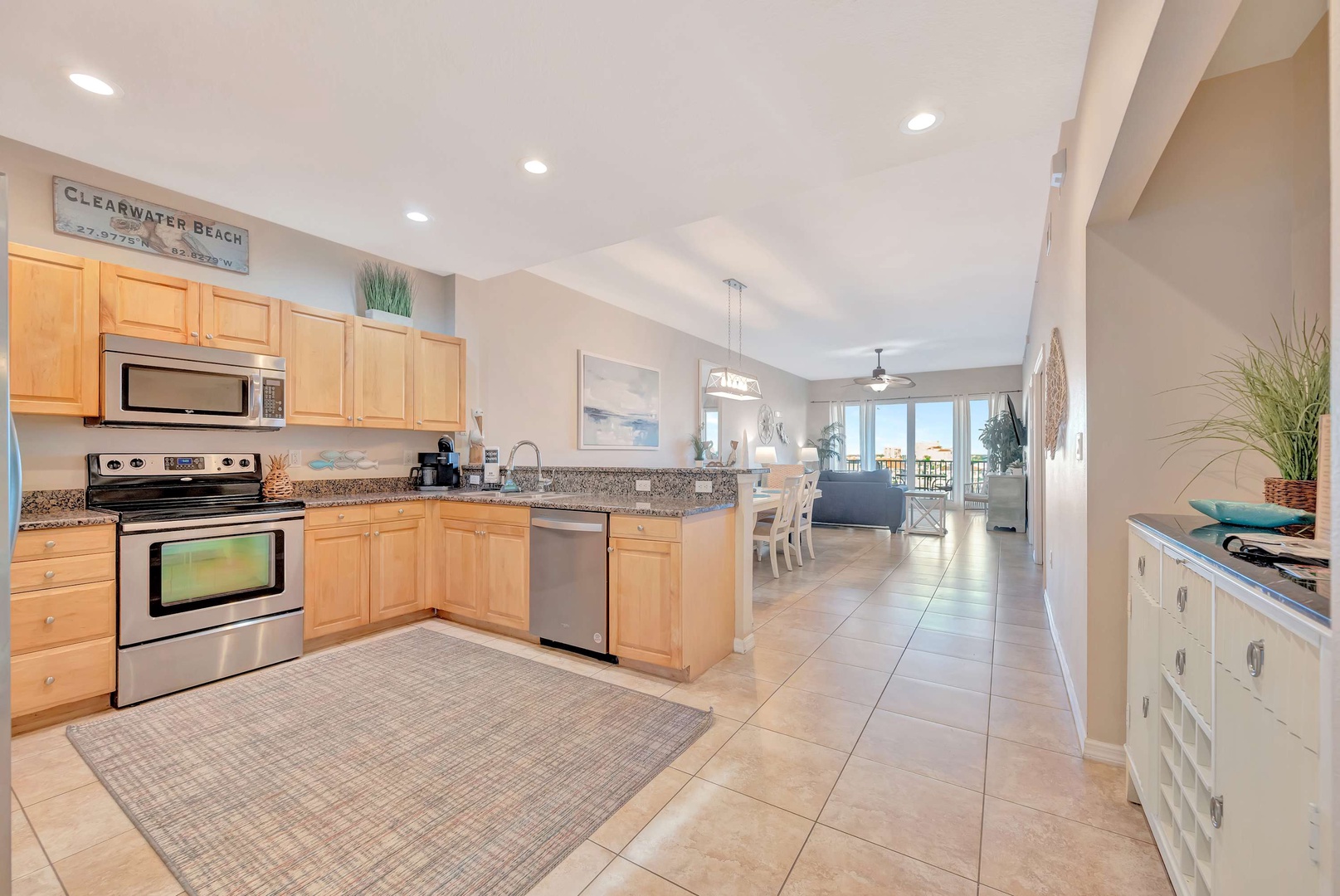 Your fully equipped kitchen with granite counters flows seamlessly into the open living area, where sunlight and coastal breezes invite you to unwind after a day at the beach.