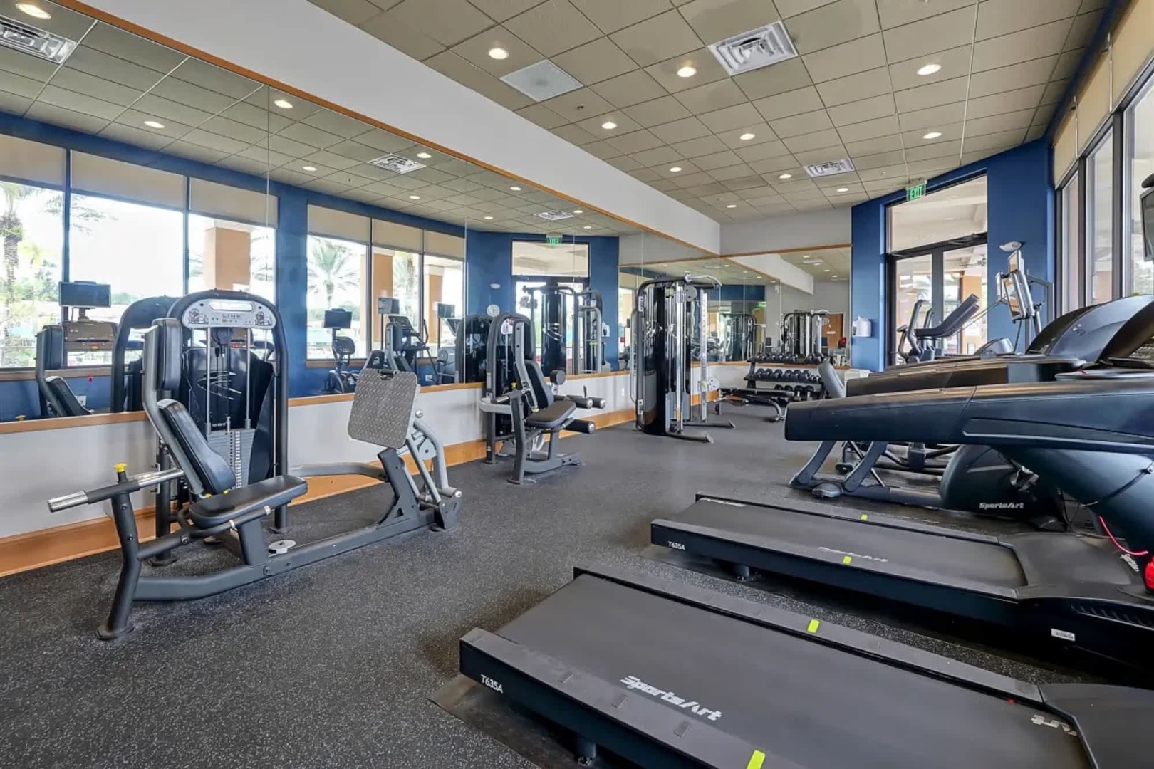 Stay on track with your fitness goals in this bright, well-equipped gym featuring cardio machines, strength training equipment, and plenty of natural light to energize your workout.