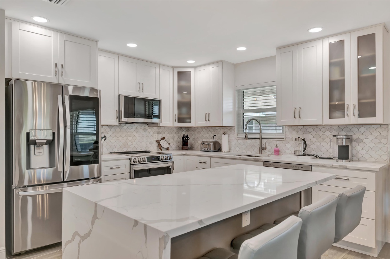 Cook your favorite meals in this stunning, fully equipped kitchen with sleek marble countertops, premium stainless steel appliances, and a spacious island perfect for gathering with loved ones.