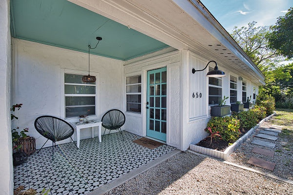 Welcome to 650—step through the turquoise-trimmed door and onto your private patio, where you can sip morning coffee surrounded by fresh gardens and coastal charm.