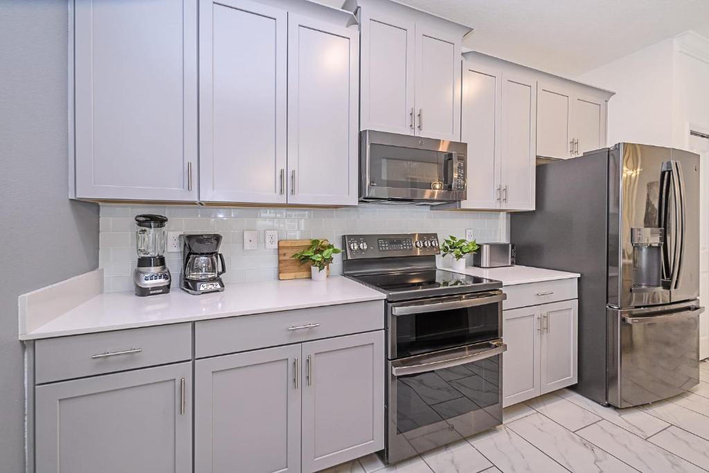 Step into your bright, fully equipped kitchen featuring sleek stainless steel appliances, modern white cabinetry, and all the tools you need to whip up your favorite meals during your stay.