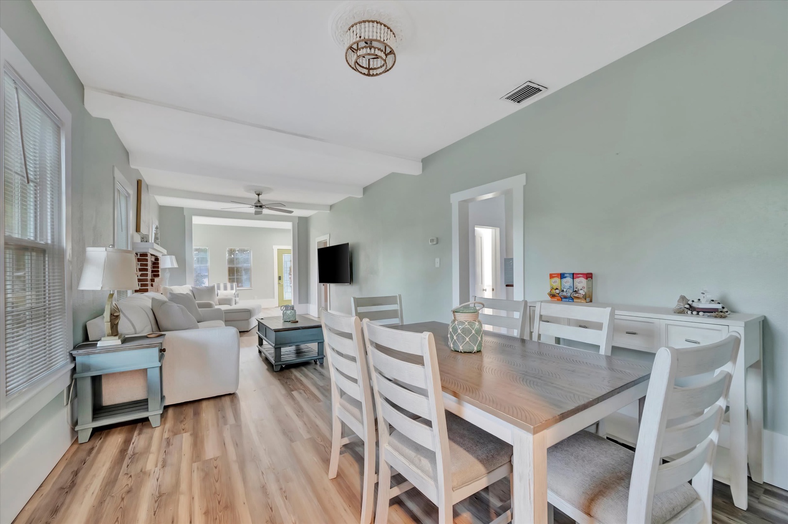 Step into your open-concept living and dining space, where soft coastal hues and abundant natural light create the perfect setting for relaxing or gathering around the table with your loved ones.