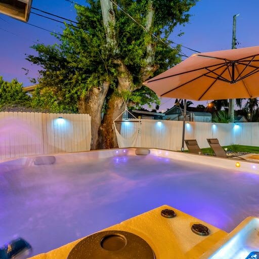 Unwind under the stars in your private hot tub, where glowing lights and a canopy of mature trees create the perfect evening retreat.