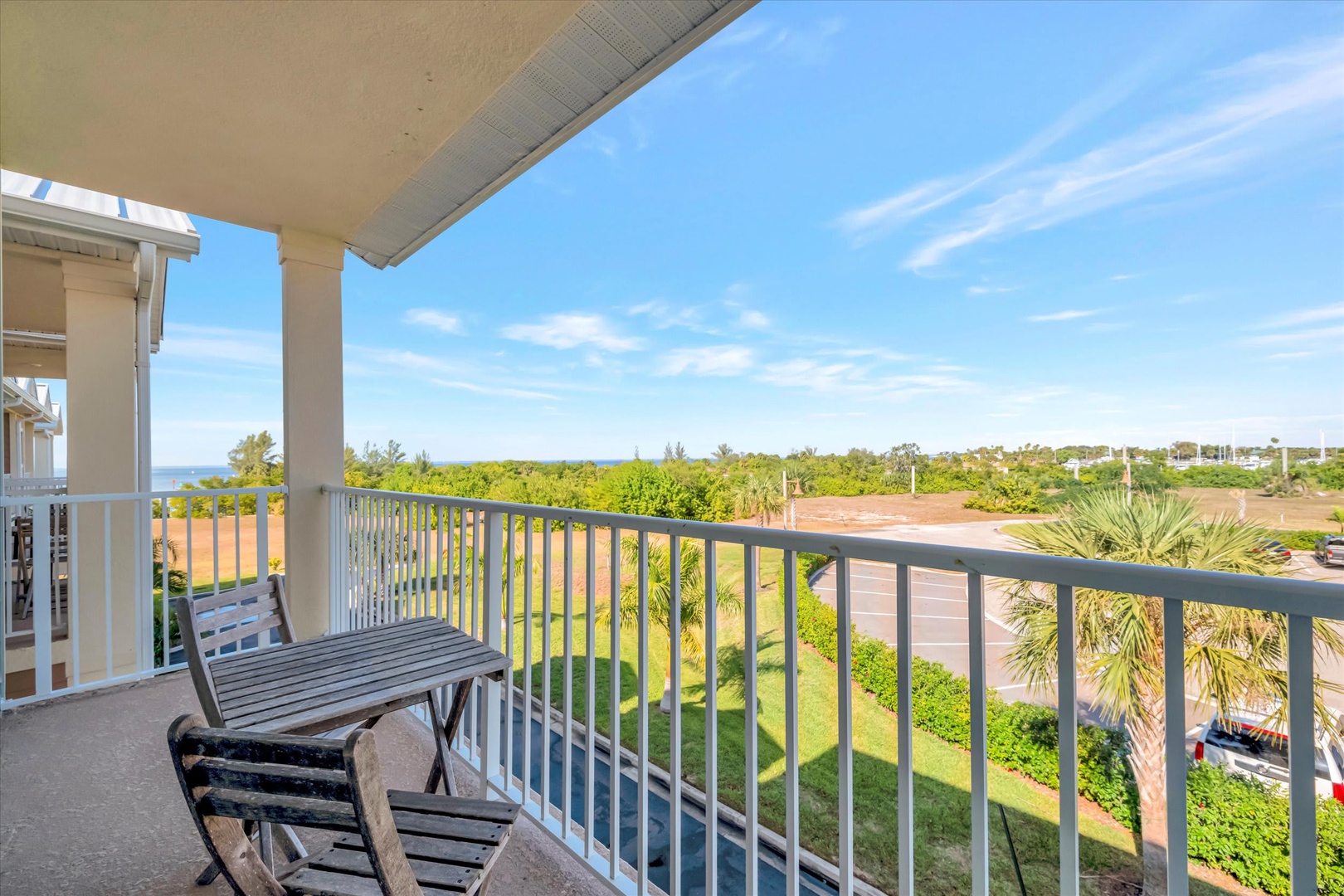 Relax on your private balcony with seating overlooking lush greenery and glimpses of the sparkling sea beyond—your perfect spot to unwind with morning coffee or evening sunsets.