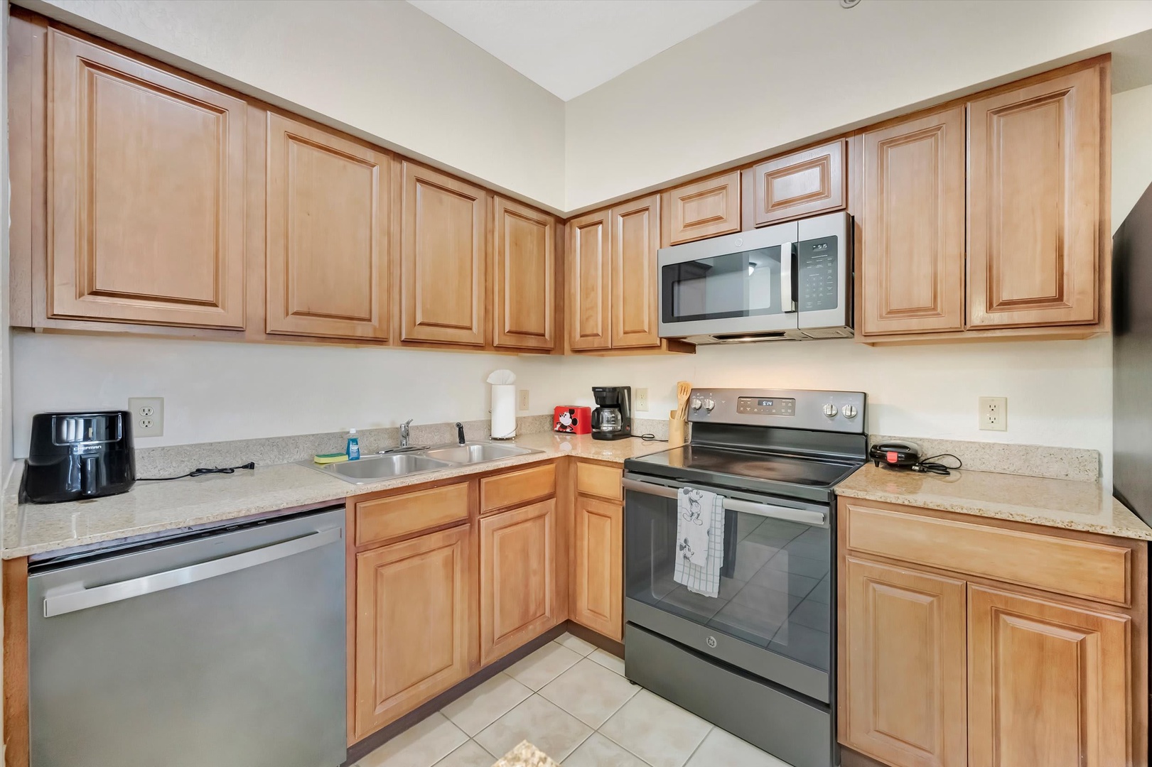 Your fully equipped kitchen awaits, featuring stainless steel appliances, warm wood cabinetry, and plenty of counter space for preparing home-cooked meals during your stay.