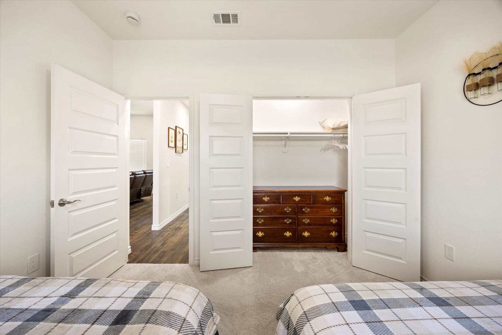 Your spacious bedroom features a generous walk-in closet with handsome wooden dresser drawers, offering ample storage to make your stay comfortable and organized.