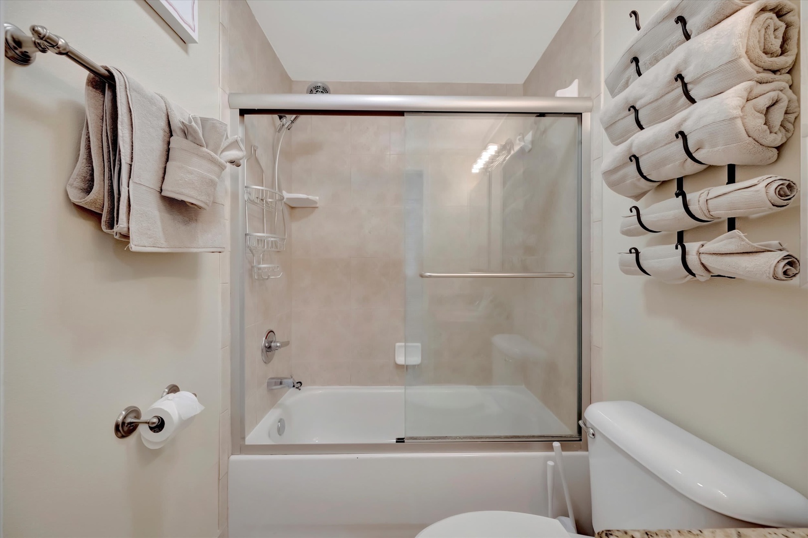 Your private bathroom features a full tub-shower combo with fresh towels neatly arranged and waiting. Bright, clean, and ready for a relaxing soak or refreshing rinse after your day.
