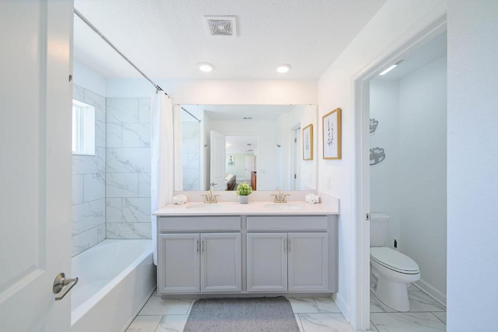 Step into your serene bathroom sanctuary, where clean lines and soft marble-look tile create a calming retreat. The spacious dual-sink vanity and separate soaking tub invite you to unwind after a day of exploring.