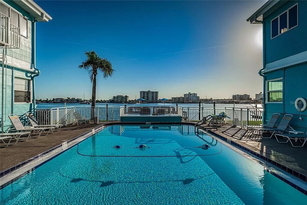 Sparkling waterfront pool framed by swaying palms and panoramic bay views, where you can soak up the sunshine from comfortable loungers.