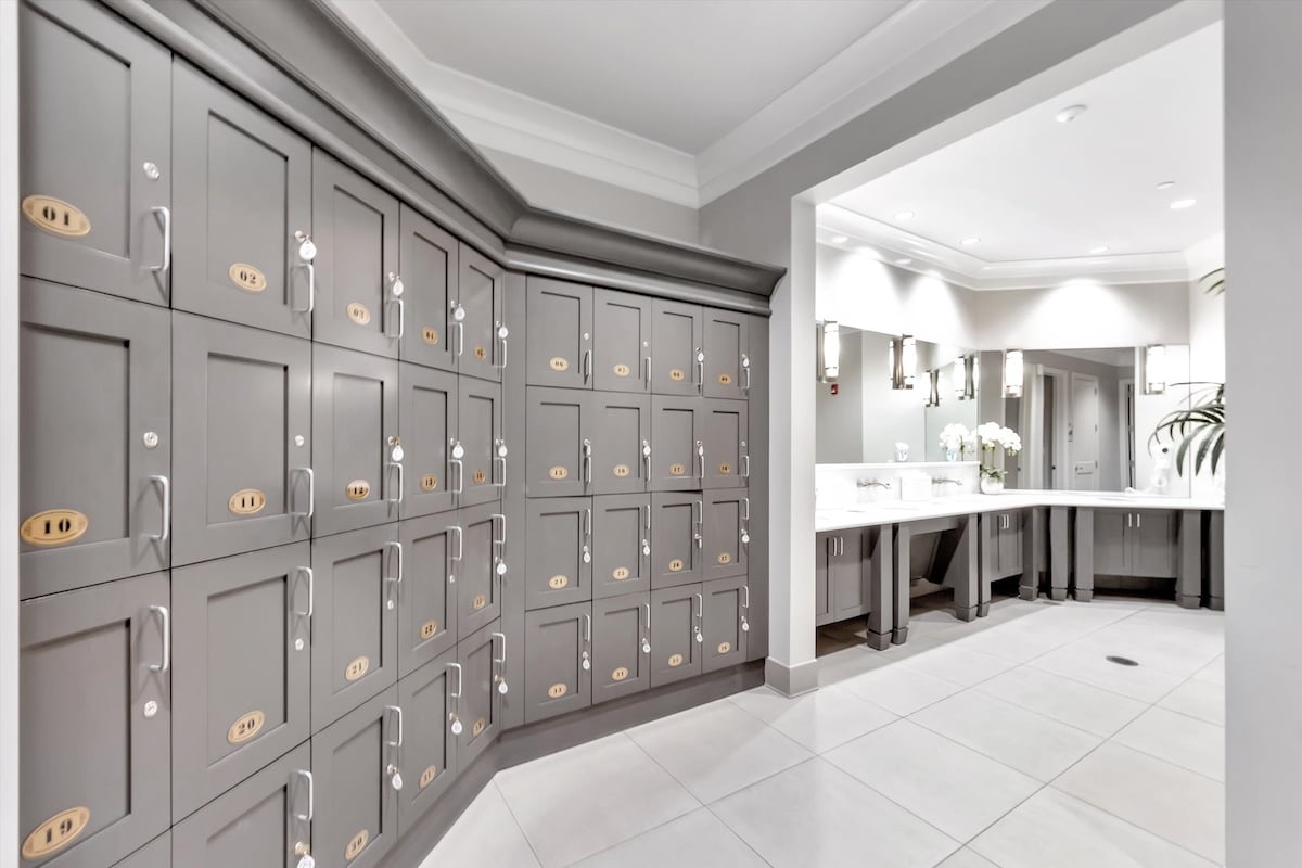 Step into this pristine locker and bathroom area where convenience meets sophistication. Store your belongings in numbered lockers while enjoying access to elegant vanities and well-appointed facilities designed for your comfort.