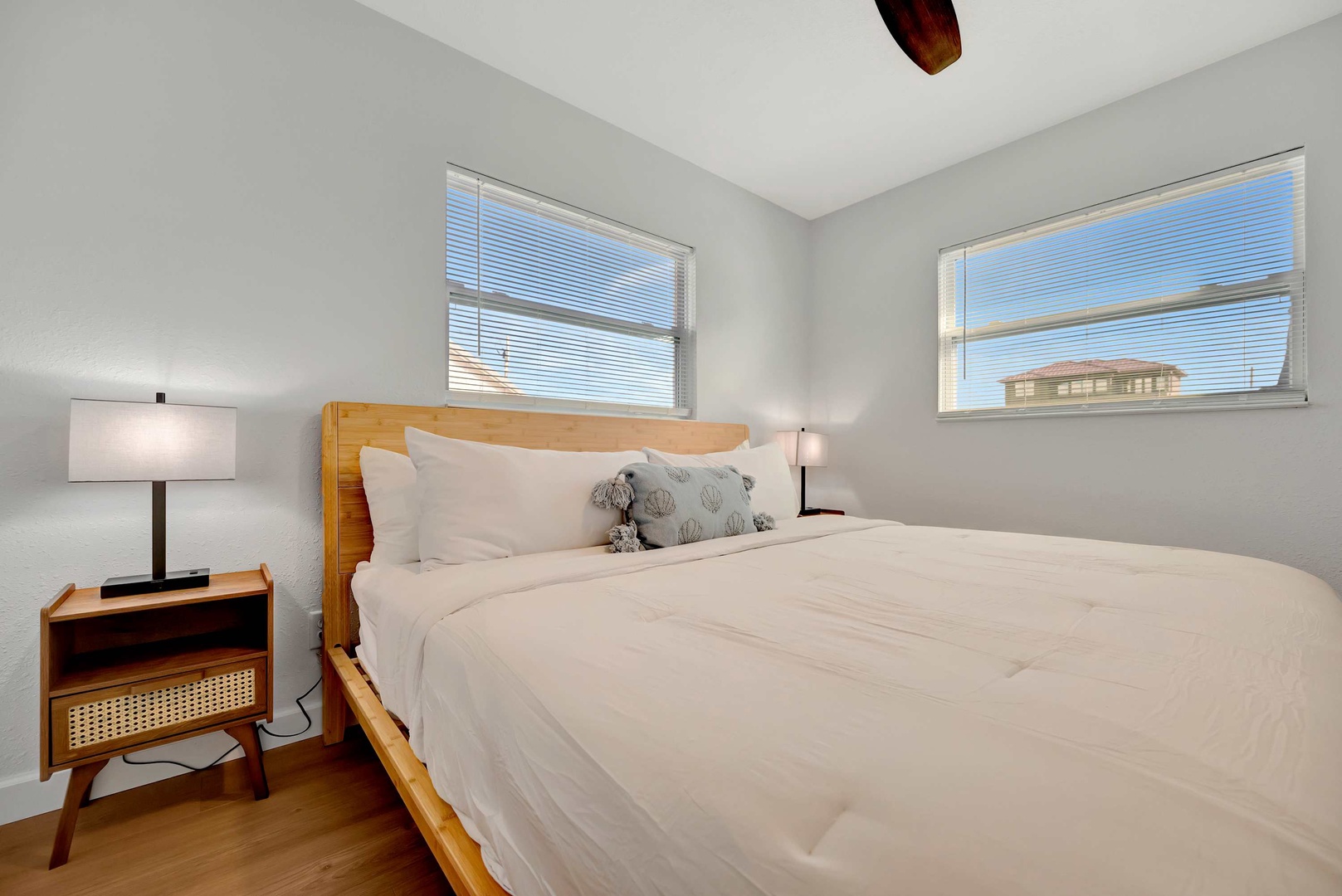 Sink into crisp linens and drift off as gentle breezes flow through your windows. Your serene bedroom retreat awaits, with warm wood accents and soft lighting to help you unwind.