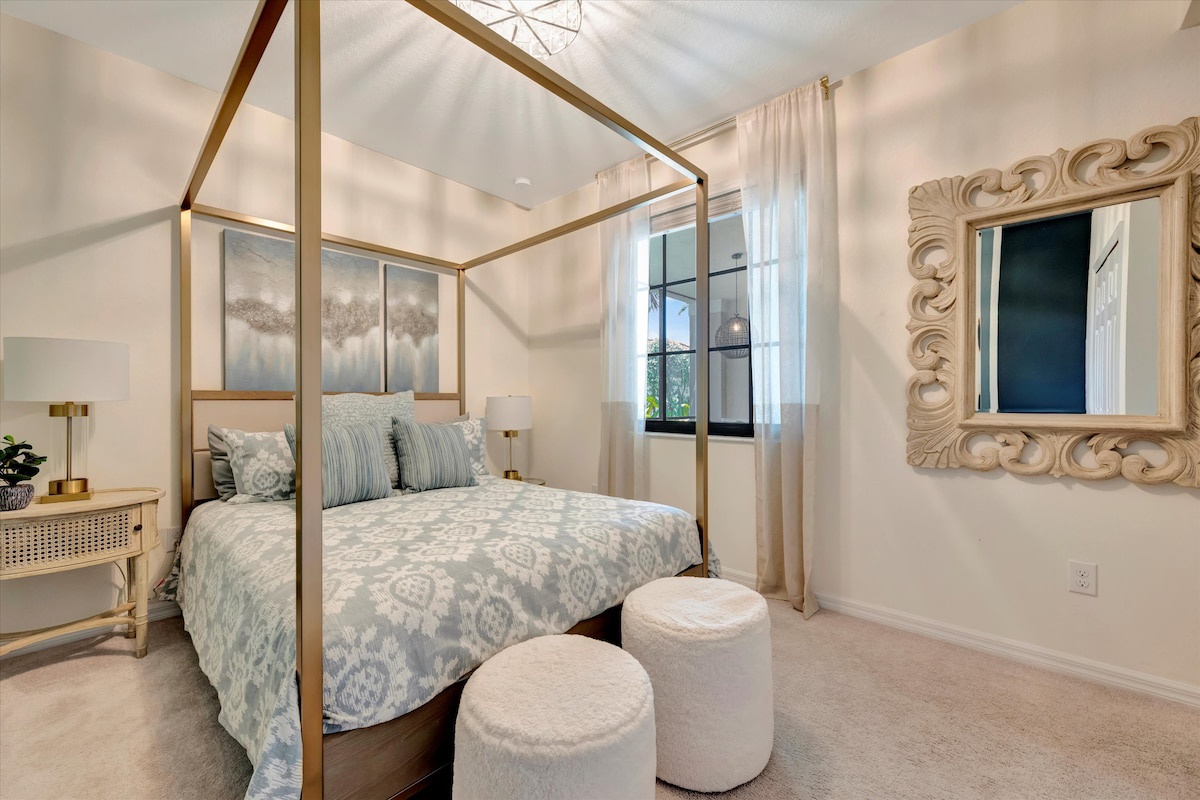 Sink into the plush canopy bed and let the soft natural light and serene blue-and-cream palette wrap you in calm. Your peaceful retreat awaits.