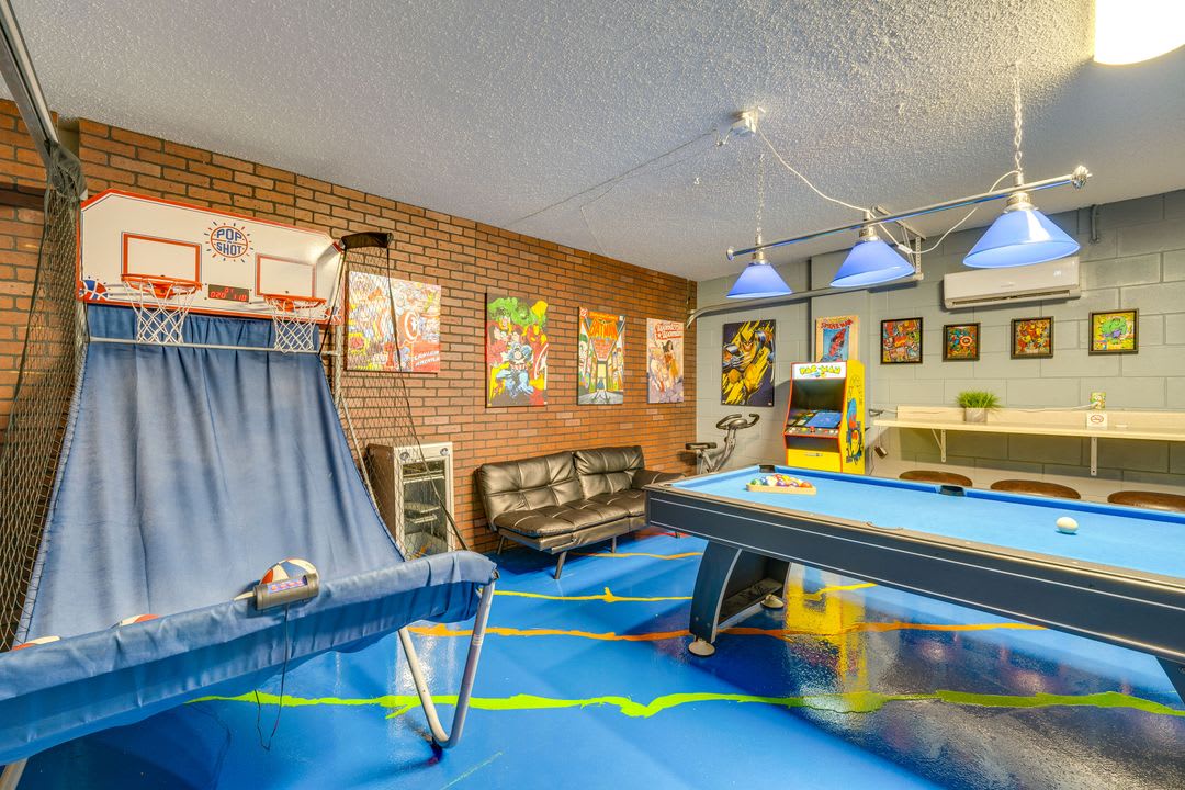 Challenge friends and family in the game room, featuring a full-size billiards table, pop-a-shot basketball, arcade console, and plenty of seating for your crew.