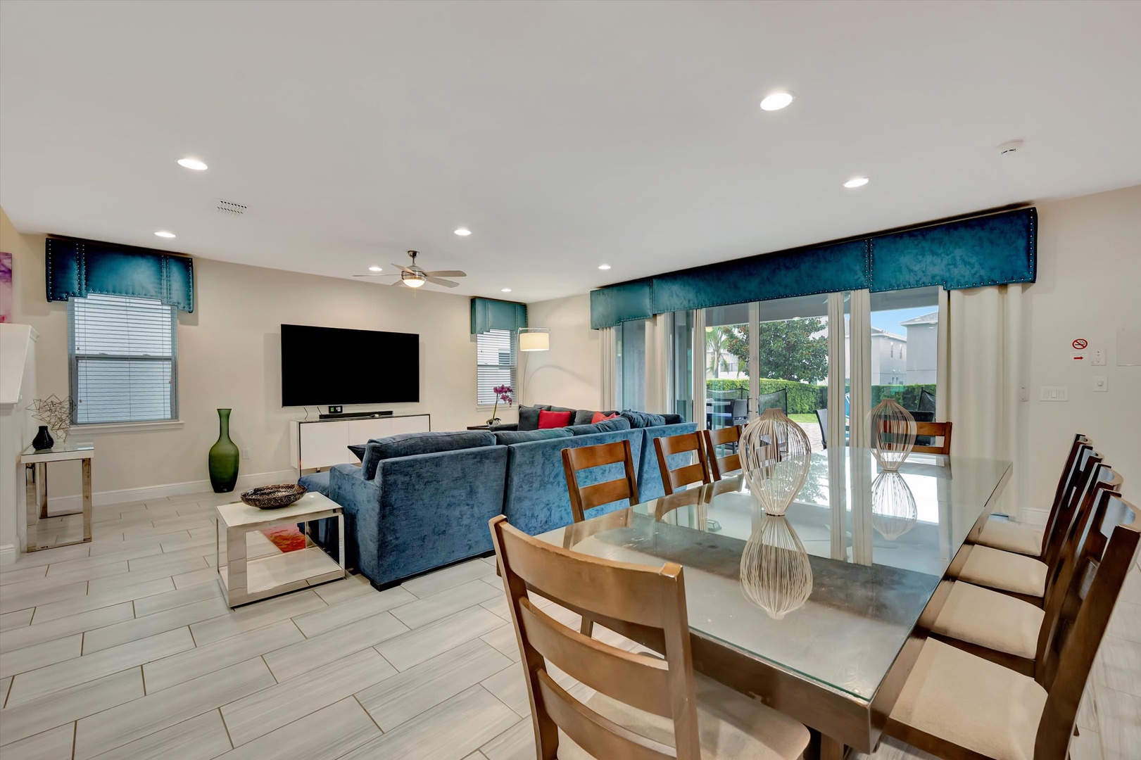 Settle into your open-concept living space where plush seating and a dining table invite you to gather. Natural light streams through sliding glass doors that open to your outdoor patio.