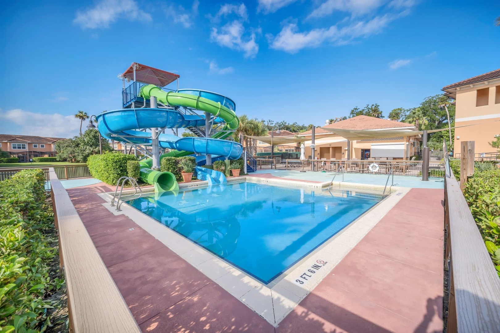 A twisting water slide splashes into a sparkling pool, promising endless fun-filled afternoons under sunny Florida skies with your family.