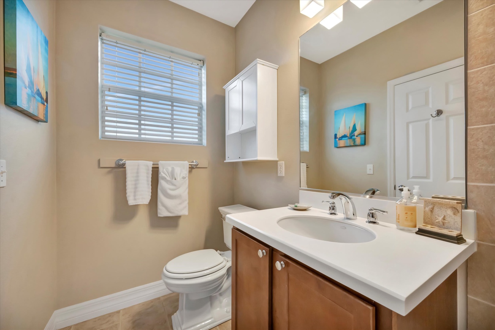 Step into your bright, sparkling bathroom with warm beige tones and thoughtful touches. Fresh towels await, and the vaulted ceiling adds a sense of openness and comfort to your daily routine.