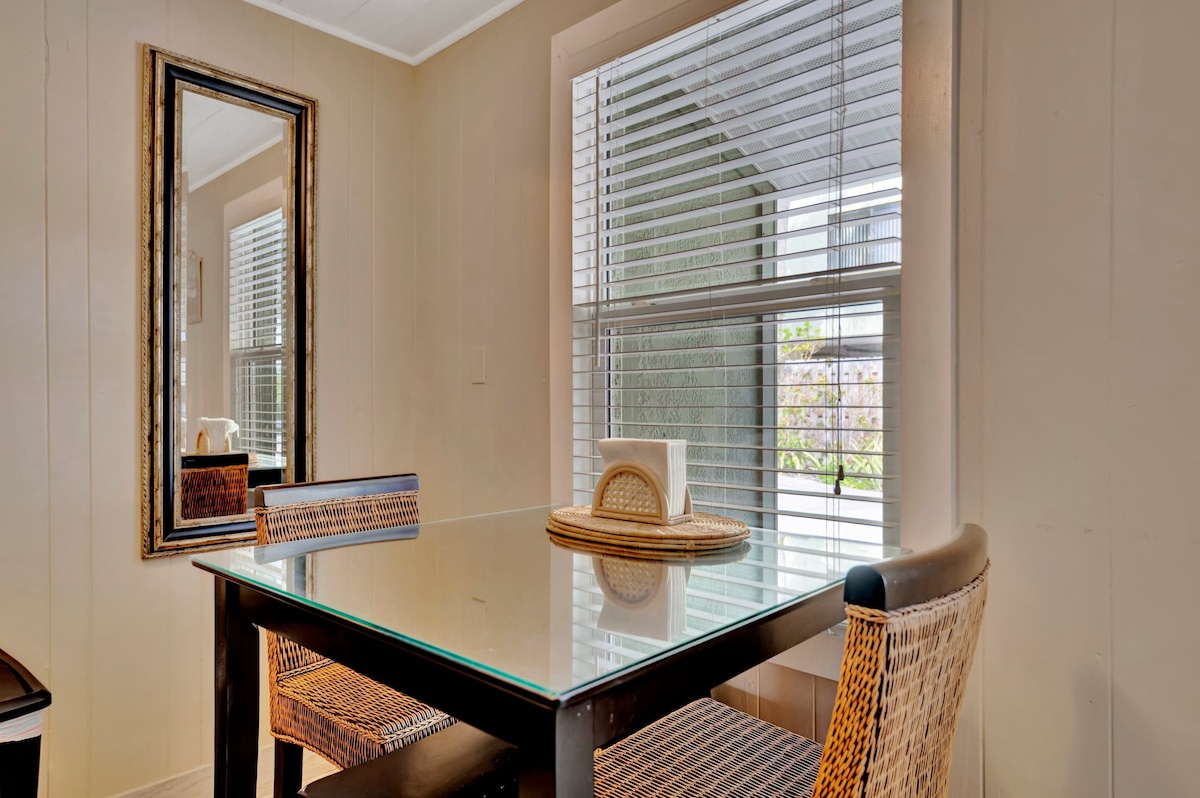 Settle into your intimate dining nook, where natural light filters through plantation shutters and woven seating invites leisurely morning coffee or quiet meals for two.
