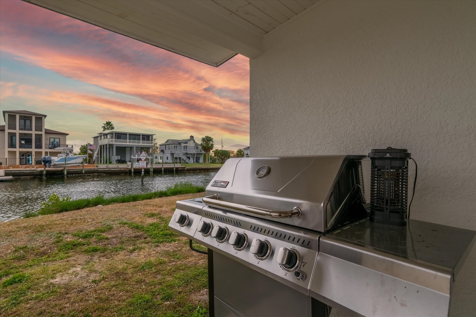 Waterfront property with canal access, featuring neighboring homes, palm trees, and a peaceful coastal neighborhood visible from the grounds.