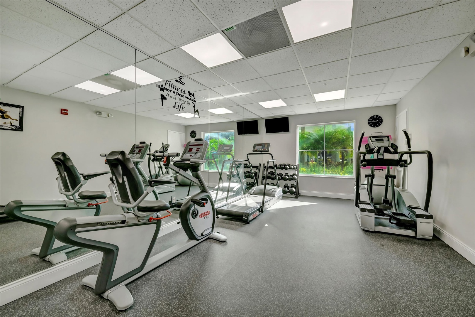 Stay active during your getaway in this well-equipped fitness center, featuring cardio machines, free weights, and strength training equipment—all bathed in natural light from tropical garden views.
