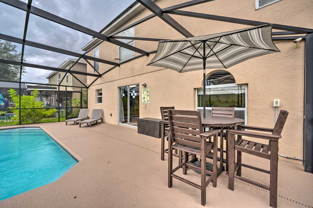 Your private screened patio awaits—perfect for alfresco dining by the pool or unwinding in the hot tub under the shade of the umbrella.