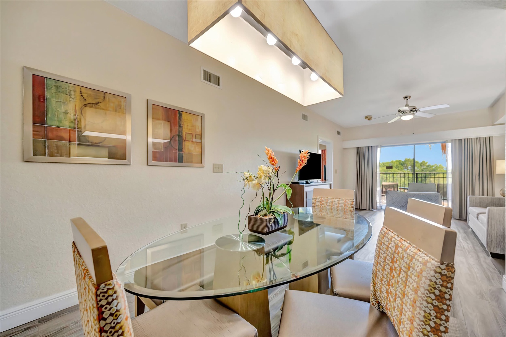 Gather around a stylish glass-top table where meals become moments, with natural light and greenery just beyond your doors.