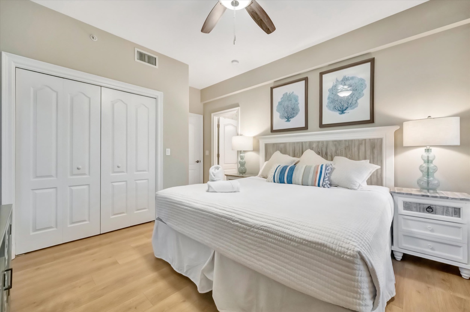 Sink into crisp white linens and let the coastal décor soothe your senses in this peaceful bedroom retreat with soft lighting and plenty of closet space.