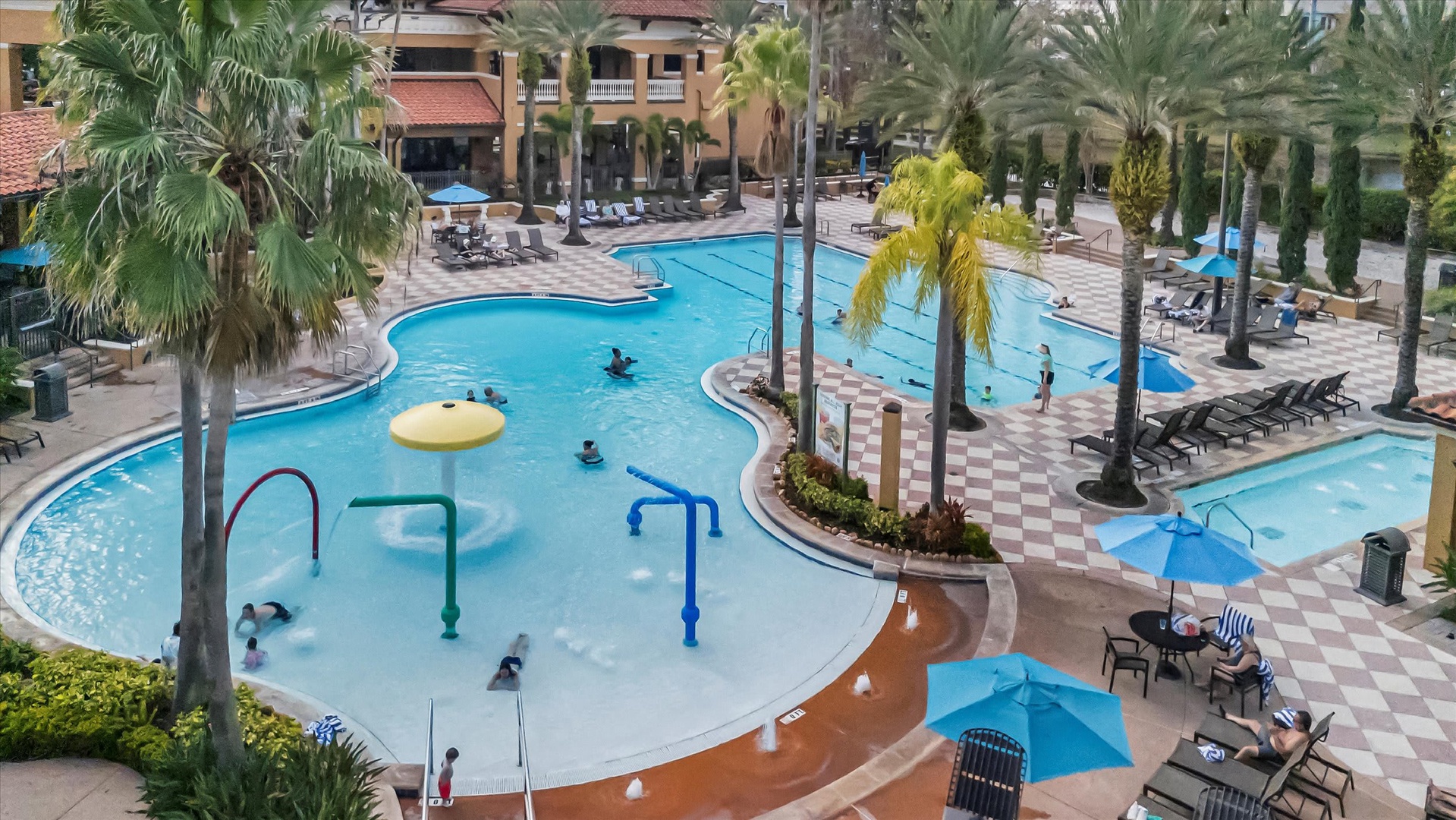 The Bella Toscana at Floridays Resort offers a unique winding lazy river pool surrounded by towering palms, colorful splash features, and spacious sun decks—perfect for families seeking relaxation and fun.