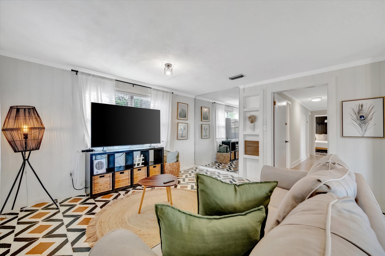 Sink into the plush sofa surrounded by thoughtful design—geometric patterns, natural textures, and warm lighting create a space that invites you to unwind and feel truly at home.
