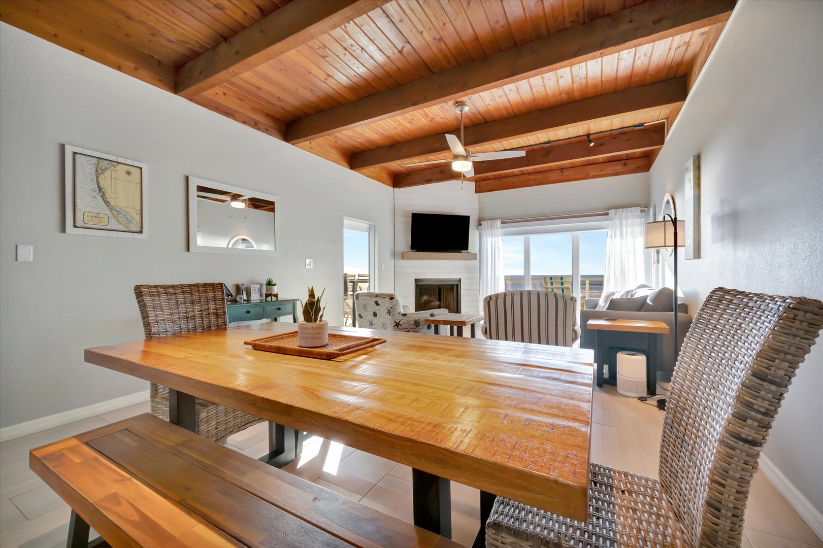 Gather around this handsome wooden table under warm beamed ceilings, with ocean views framing your meals and cozy living spaces inviting you to unwind after a day of adventure.