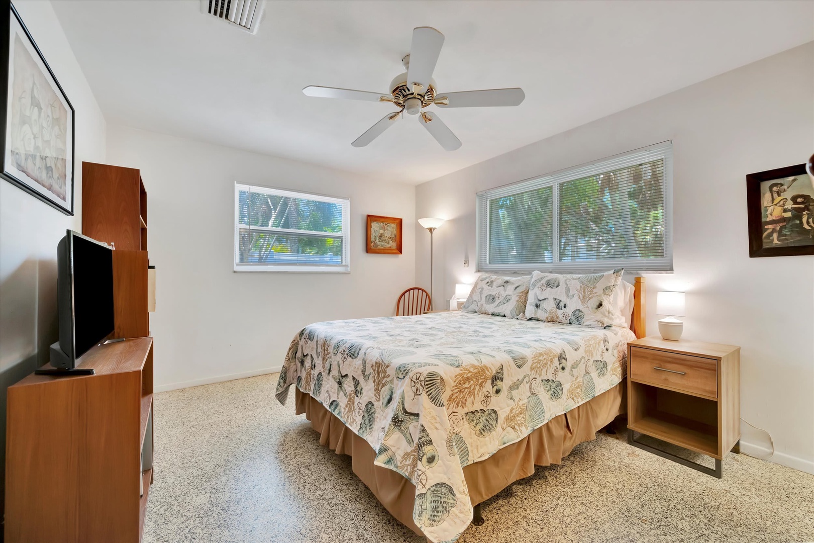 Step into your bright, comfortable retreat where tropical breezes flow through wide windows and a plush bed awaits beneath a gentle ceiling fan—your perfect escape after a day of exploring.
