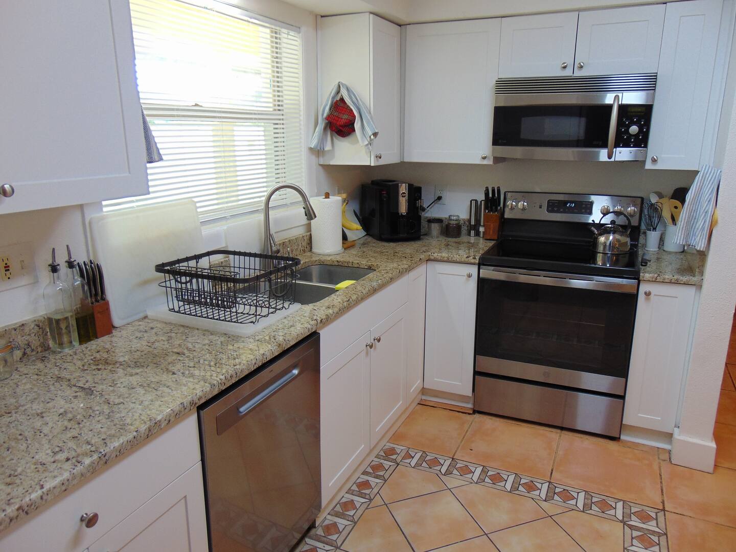 Bright, well-equipped kitchen with granite countertops, stainless appliances, and cheerful morning light—perfect for whipping up your favorite vacation breakfasts.