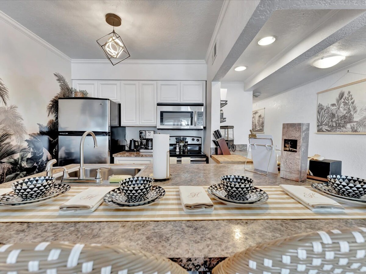 Your fully equipped kitchen awaits with granite counters, modern appliances, and stylish place settings ready for memorable meals together.