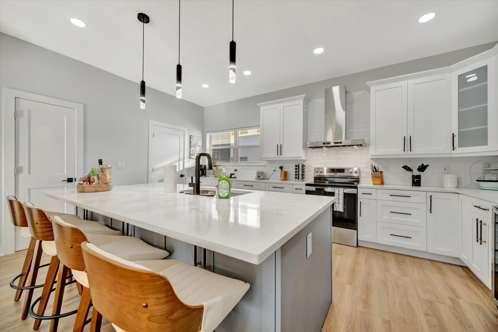 A bright, modern kitchen with gleaming countertops and a spacious island—perfect for preparing your favorite meals. Natural light pours through the windows, making it an inviting space to start your mornings.