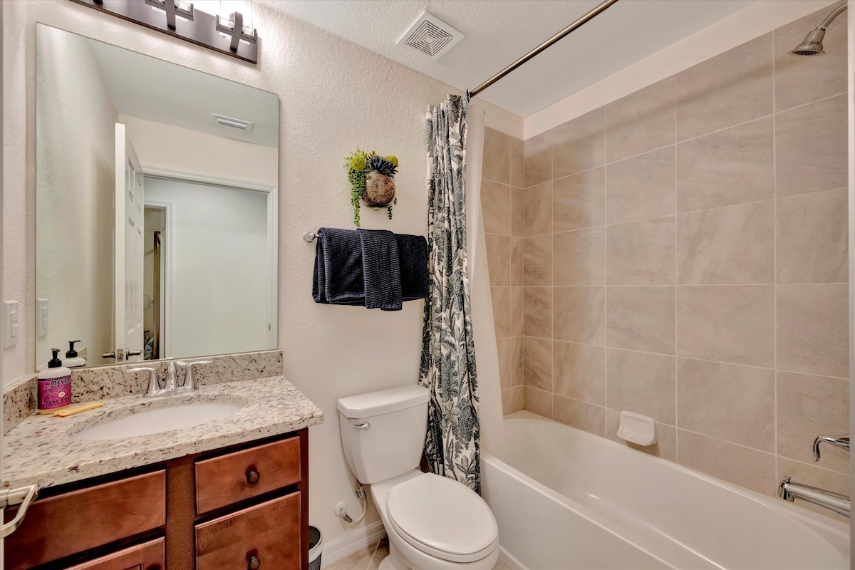 Your private bathroom features warm neutral tones, a granite vanity with ample counter space, and a relaxing tub-shower combo—perfect for unwinding after a day of adventure.