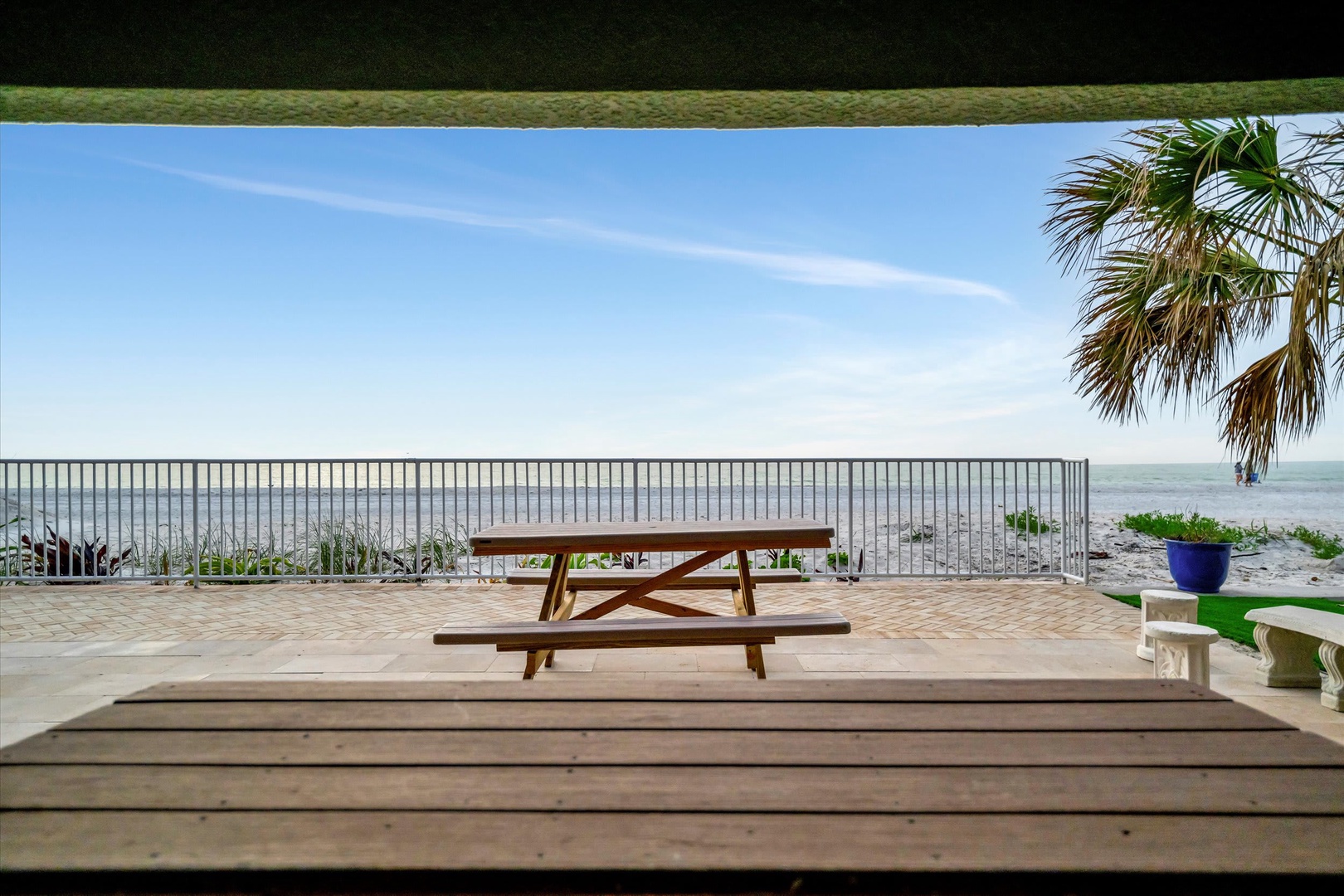 Your private oceanfront patio with a picnic table and swaying palms offers the perfect spot to soak in endless sea views and coastal breezes.