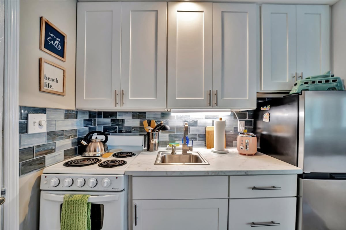 Your fully equipped kitchen invites you to prepare fresh meals with ease. Bright lighting, modern appliances, and coastal touches create a cheerful space where you'll love starting your mornings.
