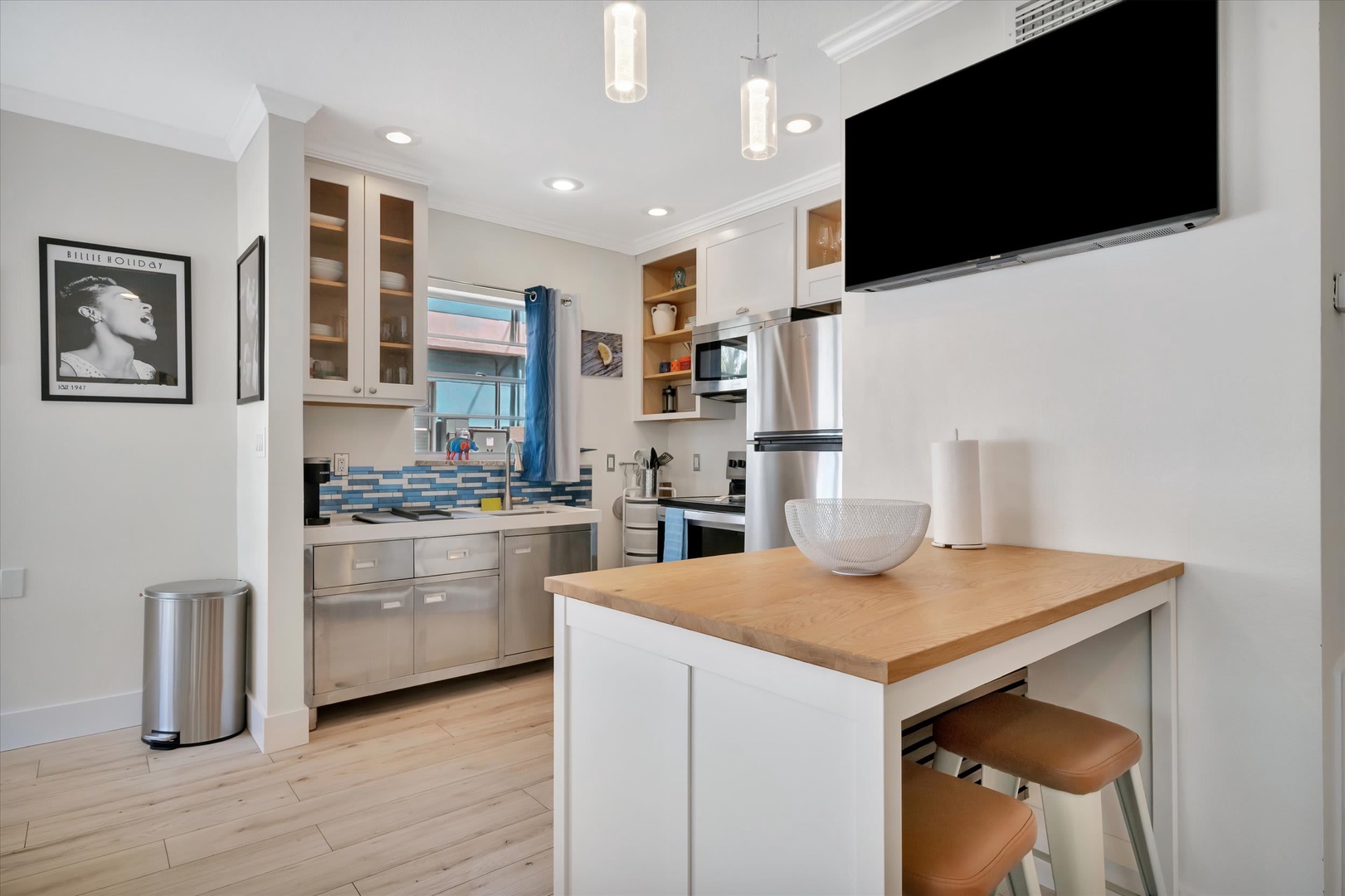Step into your bright, modern kitchen where light wood counters and colorful backsplash tiles add cheerful charm. The island invites casual meals or morning coffee as you plan your day's adventures.