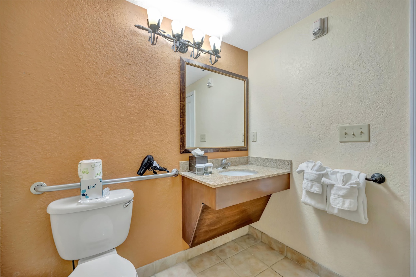 Refresh and unwind in your private bathroom, complete with plush towels, a vanity mirror, and thoughtful accessibility features for your comfort.