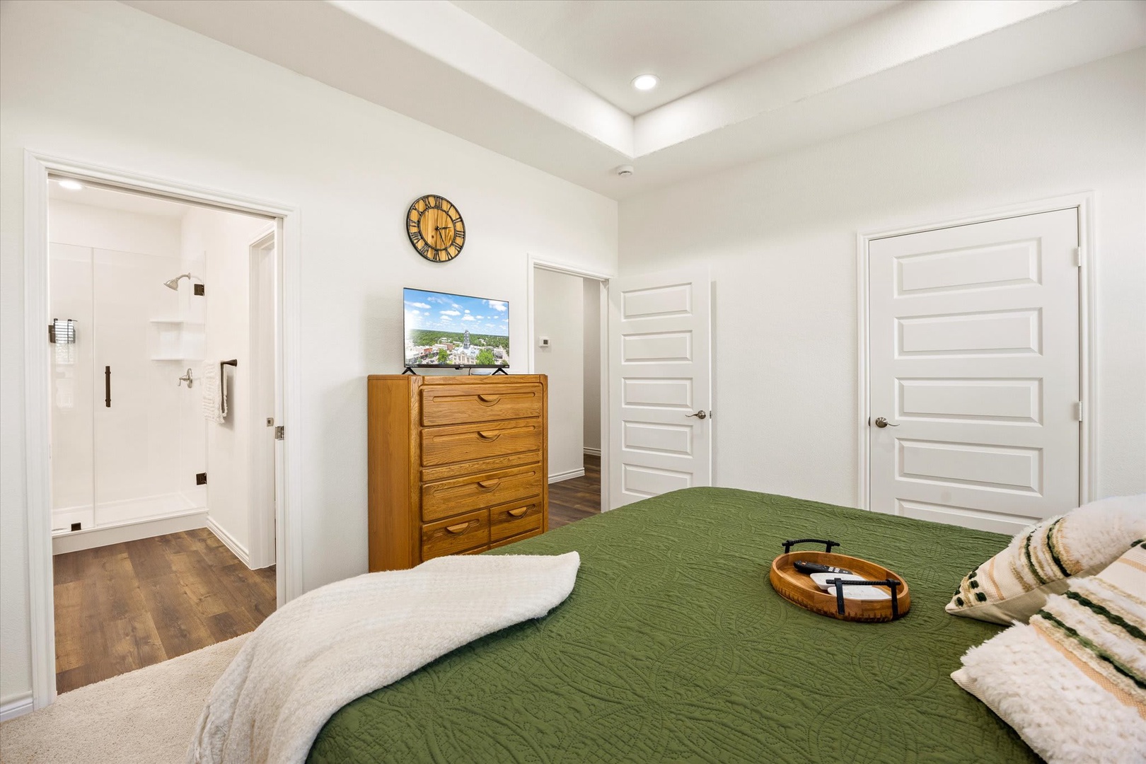 Unwind in your spacious bedroom with high ceilings and a cozy green-quilted bed. Your private ensuite bathroom awaits, and there's plenty of storage for all your vacation essentials.