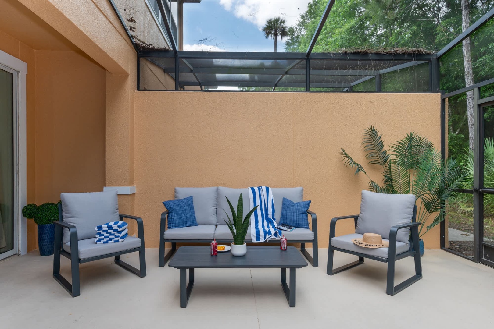 Step outside to your private screened patio, where comfy seating and lush greenery create the perfect spot to unwind with morning coffee or an evening chat.