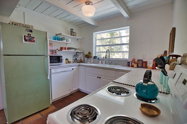 Your charming retro kitchen invites you to whip up meals with vintage-inspired appliances and plenty of counter space. Bright natural light and open shelving create a cheerful, functional cooking space.