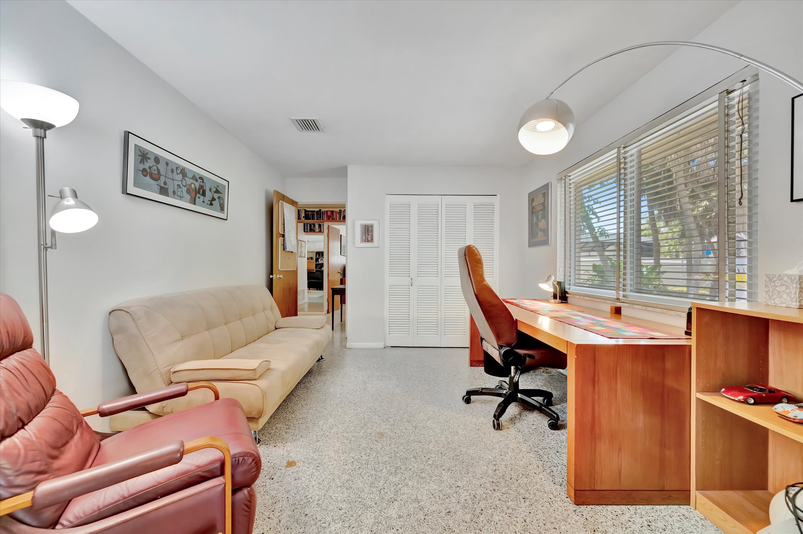 Settle into your versatile living space, where a comfortable futon and dedicated desk area offer room to relax or catch up on work. Natural light filters through the blinds, creating a bright, welcoming retreat.
