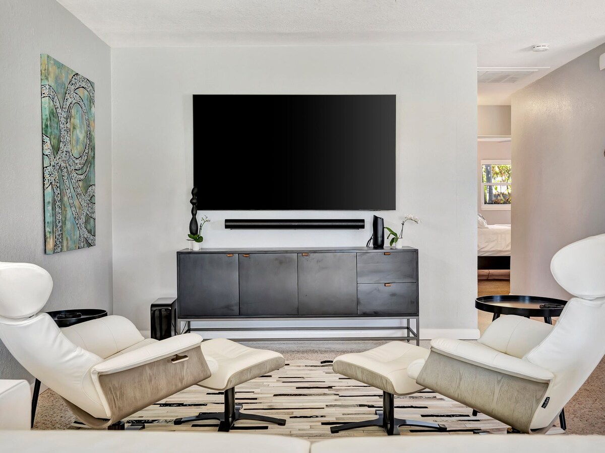 Sink into modern comfort in this sleek living space, where contemporary design meets relaxation. Two white leather lounge chairs invite you to unwind, while the clean lines and minimalist aesthetic create a perfect escape.